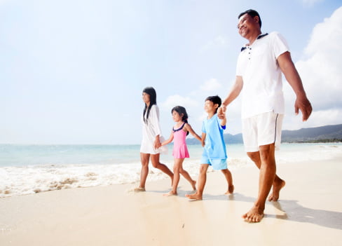 Thai family walking on the beach.