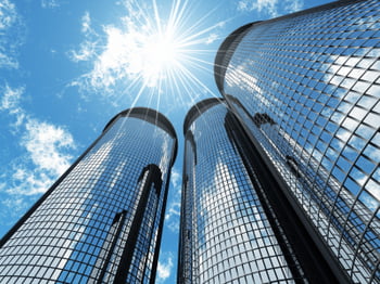 High modern skyscrapers on a background of the blue sky and in solar patches of light